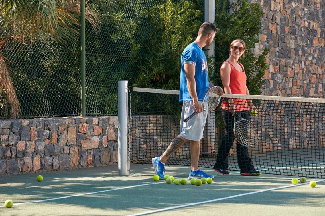 Tennisplatz im Island Hotel auf Kreta mit einem Paar das Tennisschläger hält