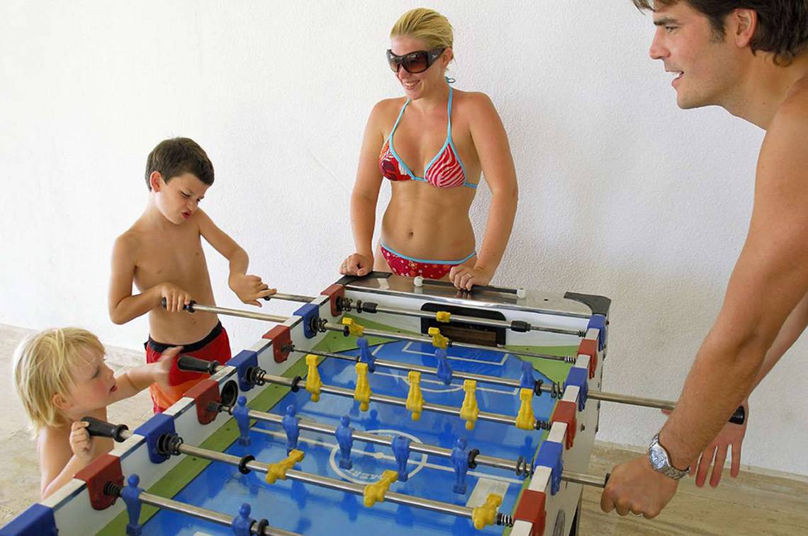 Eine Familie spielt Tischfußball im KoruMar Hotel De Luxe