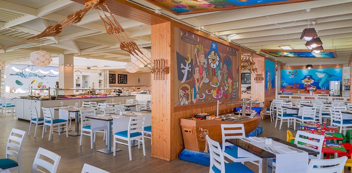 Innenansicht des Restaurants im H10 Suites Lanzarote Gardens Hotel mit bunten Wandmalereien und blauen Stühlen.