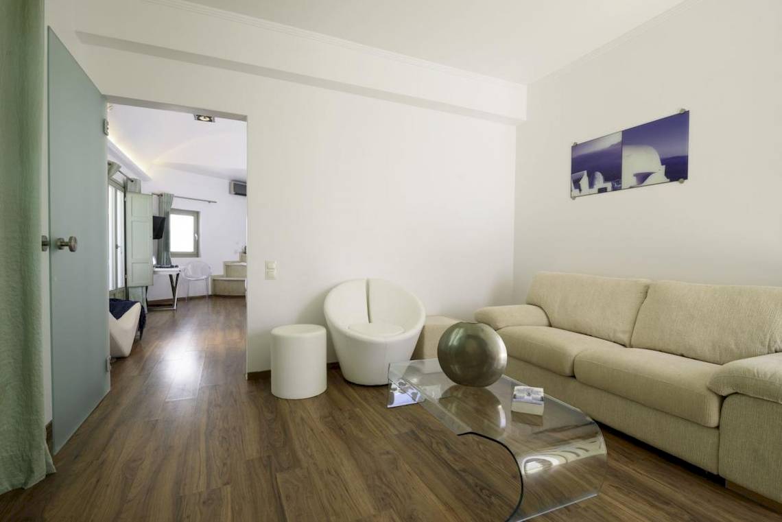 Wohnbereich im La Mer Deluxe Hotel mit Couch, Tisch und kunstvollem Metallobjekt.
