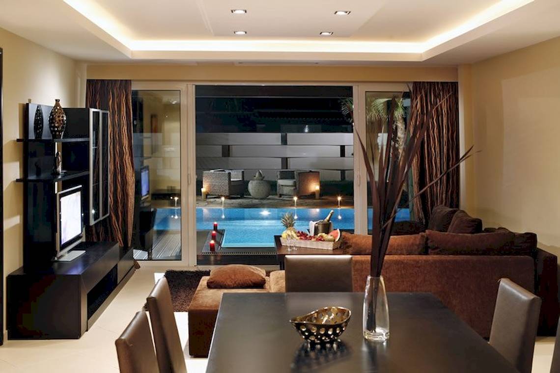 Wohnzimmer im Olympia Golden Beach Resort mit Blick auf den Pool.