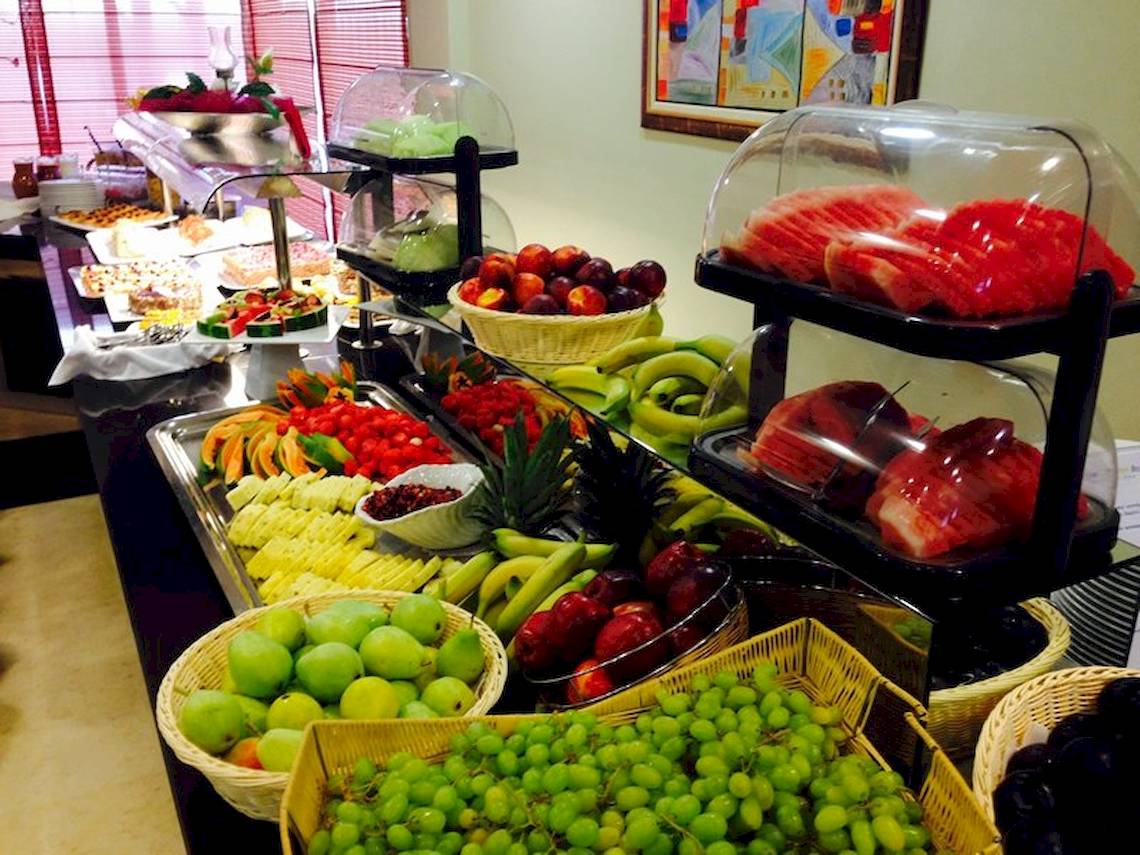 Buffet mit verschiedenen Früchten wie Äpfel, Bananen, Melonen und Trauben.