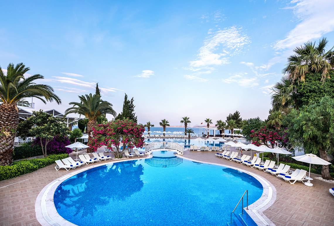 Poolbereich des LABRANDA TMT Bodrum Hotels mit Sonnenliegen und Palmen