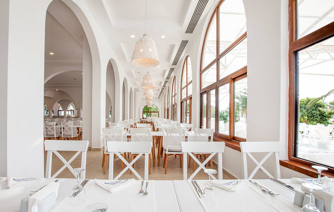 Innenbereich des LABRANDA TMT Bodrum Restaurants mit vielen weißen Tischen und Stühlen.