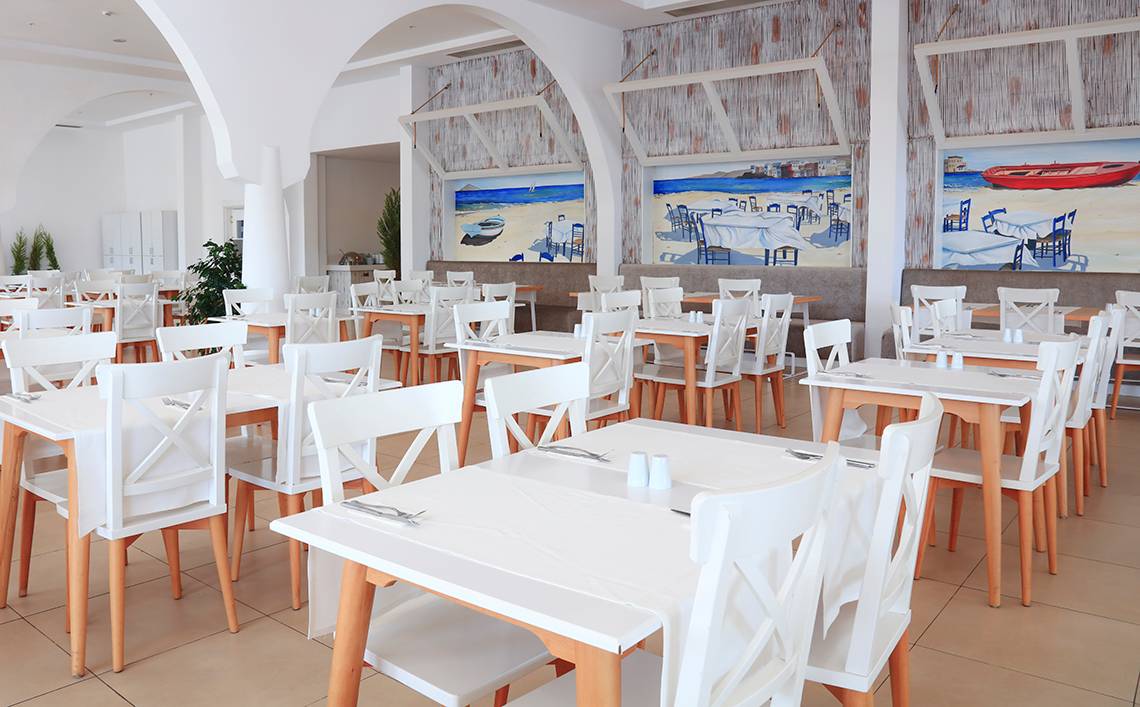 Foto des Restaurant-Innenbereichs des LABRANDA TMT Bodrum mit weißen Tischen und Stühlen.