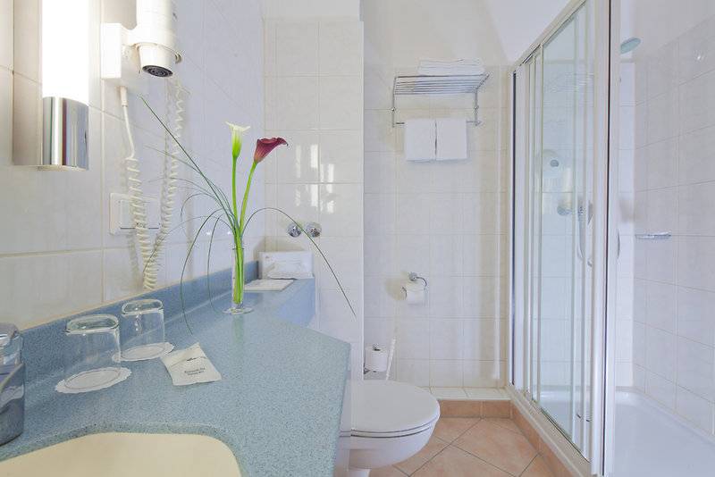 Badezimmer im Hamburg Mitte Hotel mit Dusche, Toilette und Waschbecken.