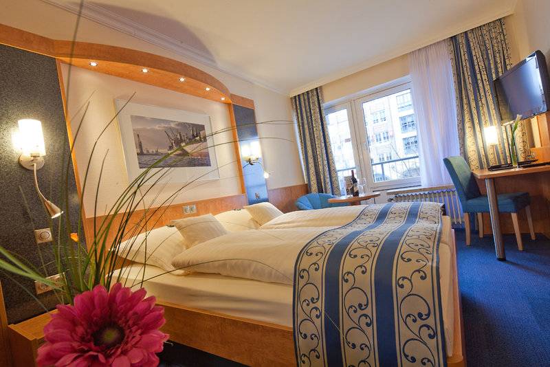 Doppelbettzimmer im Hotel Hamburg Mitte mit modernen Möbeln und Ausblick auf die Stadt.