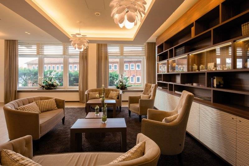 Hamburg Mitte Hotel Lobby mit Möbeln, Sofas, Tischen, Fenstern und Deckenlampen.