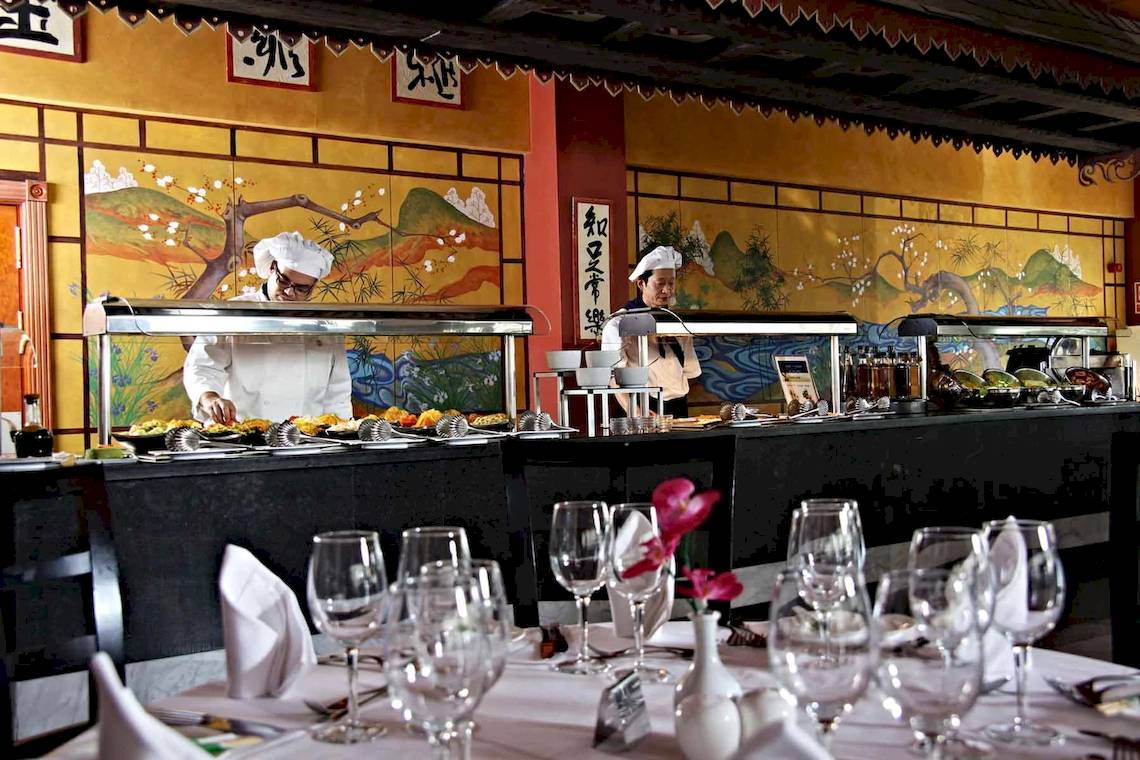 Buffettisch im Hotel Bahia Principe Sunlight Costa Adeje mit asiatischen Gemälden an der Wand.