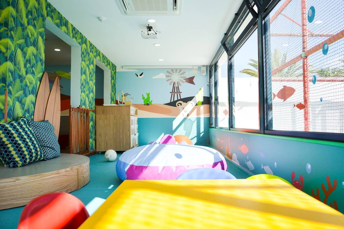 Kinderzimmer im H10 Suites Lanzarote Gardens mit farbenfrohen Wänden und Spielzeug.