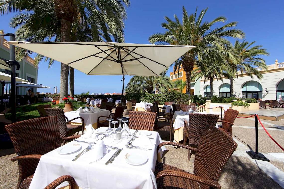 Gartenrestaurant im Bahia Principe Sunlight Costa Adeje Hotel mit Sonnenschirmen und Palmen