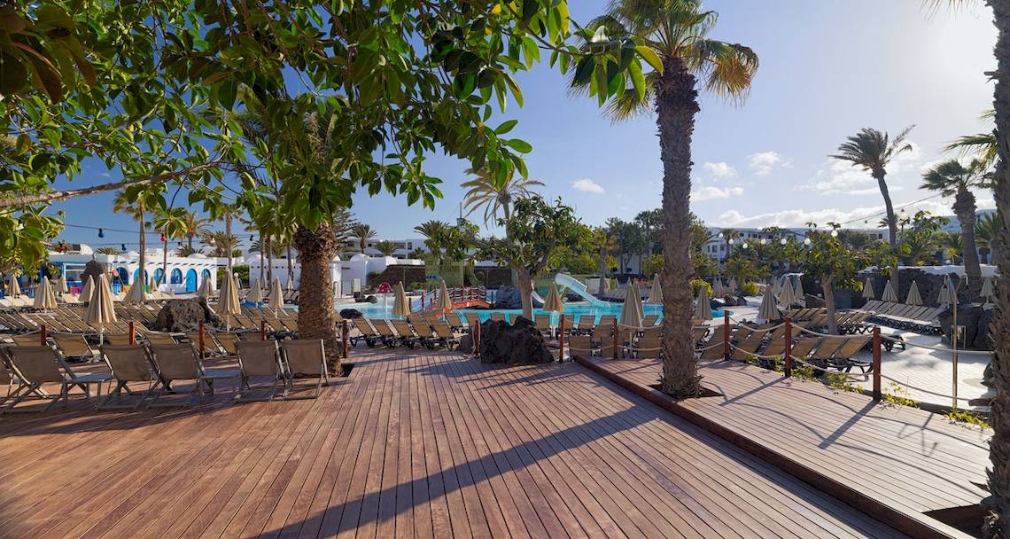 Außenbereich des H10 Suites Lanzarote Gardens Hotels mit Pool, Liegestühlen und Palmen