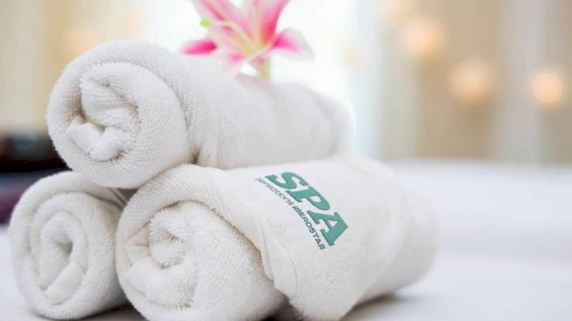 Drei weiße Handtücher mit der Aufschrift SPA auf einem Hotelbett im Iberostar Malaga Playa.