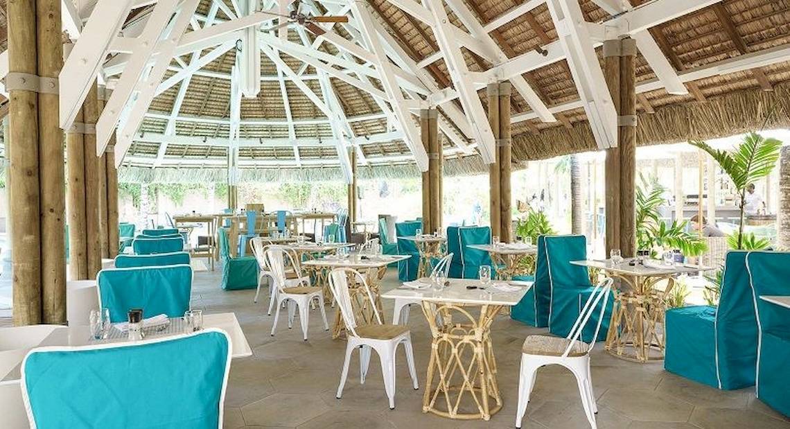 Innenbereich des Recif Attitude Restaurants mit blauen und weißen Stühlen und Tischen.