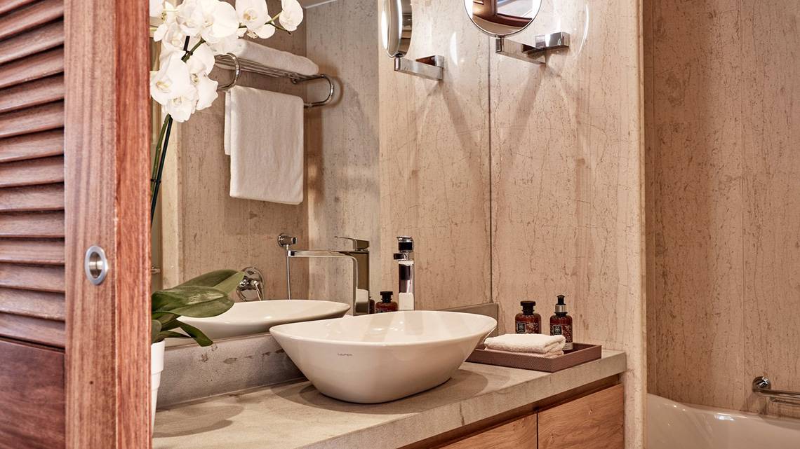 Ein Badezimmer im Blue Palace Resort & Spa mit Marmorwänden, einem Waschbecken und einer Badewanne.