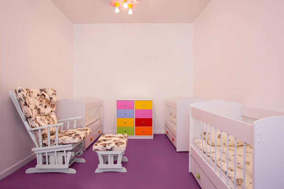 Kinderzimmer im IC Santai Family Resort mit rosa Wänden, violettem Boden und bunten Möbeln.