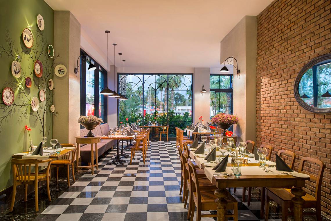 Innenansicht des Restaurants im IC Santai Family Resort mit grünen Wänden und einem Schachbrettmusterboden.