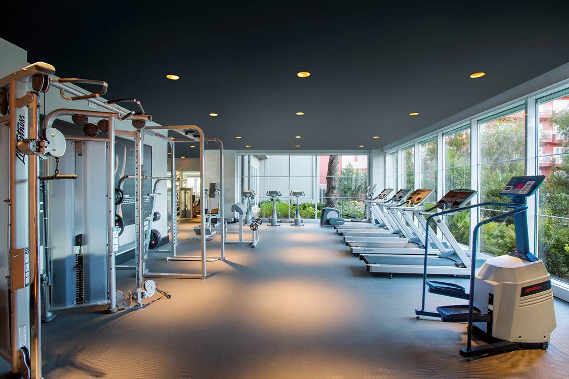 Fitnesscenter im IC Santai Family Resort mit vielen Geräten und großen Fenstern.