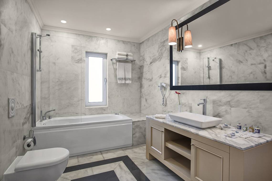 IC Santai Family Resort Badezimmer mit Badewanne, Waschbecken, Spiegel und Toilette.