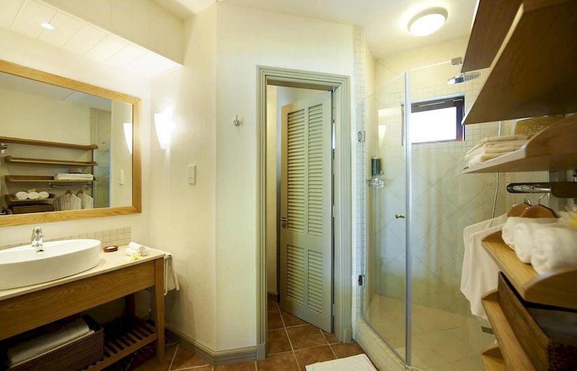 Badezimmer im Veranda Paul et Virginie Hotel & Spa mit Spiegel, Waschbecken und Dusche.