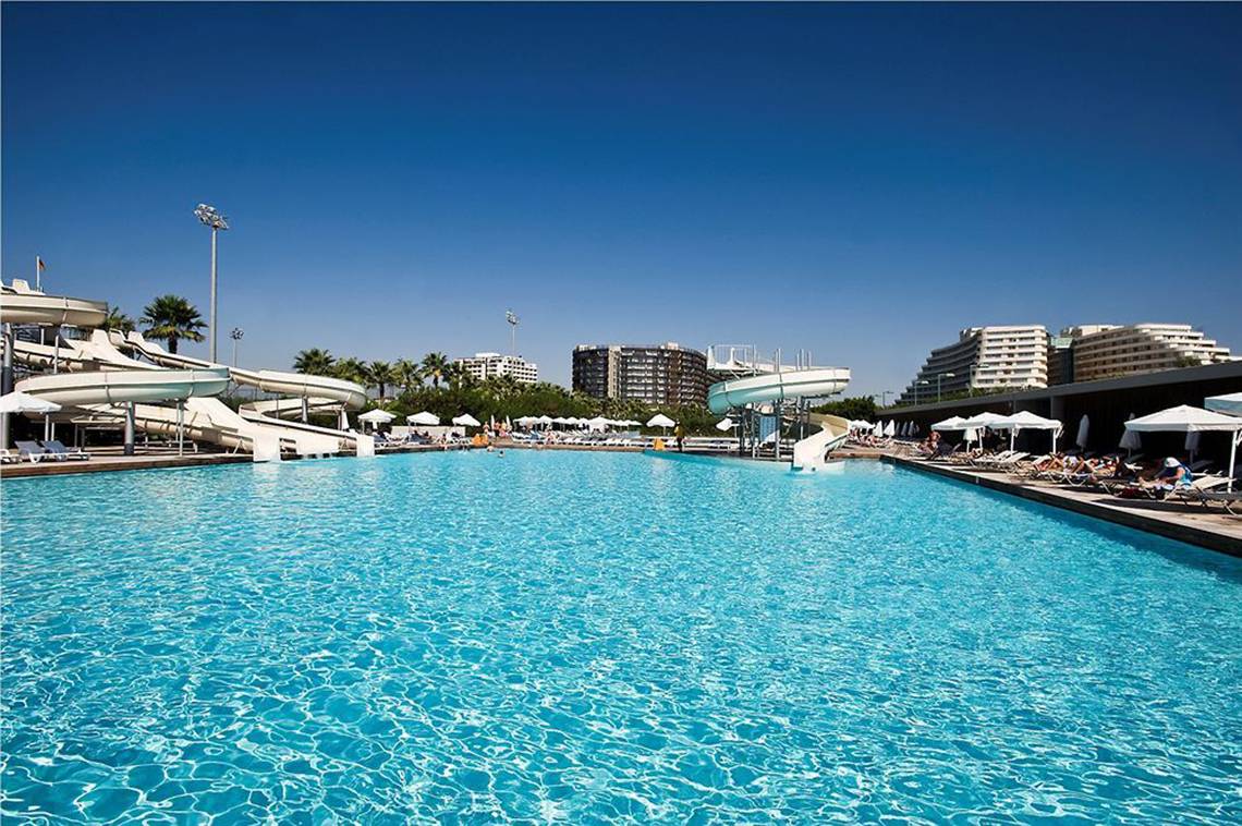 Außenpool des Nirvana Cosmopolitan Hotels mit Wasserrutschen und Sonnenliegen.