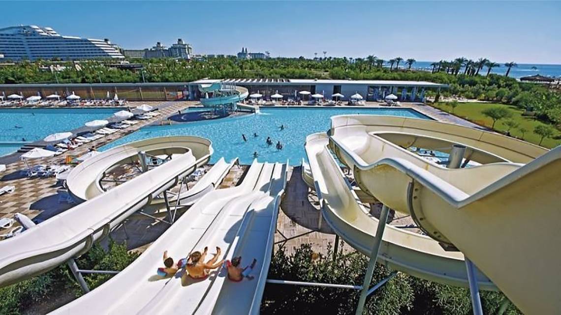 Wasserrutschen im Nirvana Cosmopolitan Hotel mit Schwimmbad und Palmen im Hintergrund.
