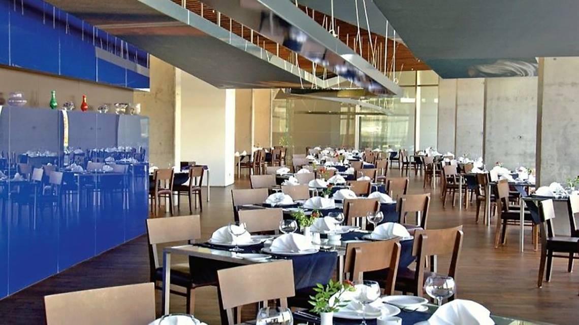 Ein blau gefliester Speisesaal im Nirvana Cosmopolitan Hotel mit gedeckten Tischen und Stühlen.