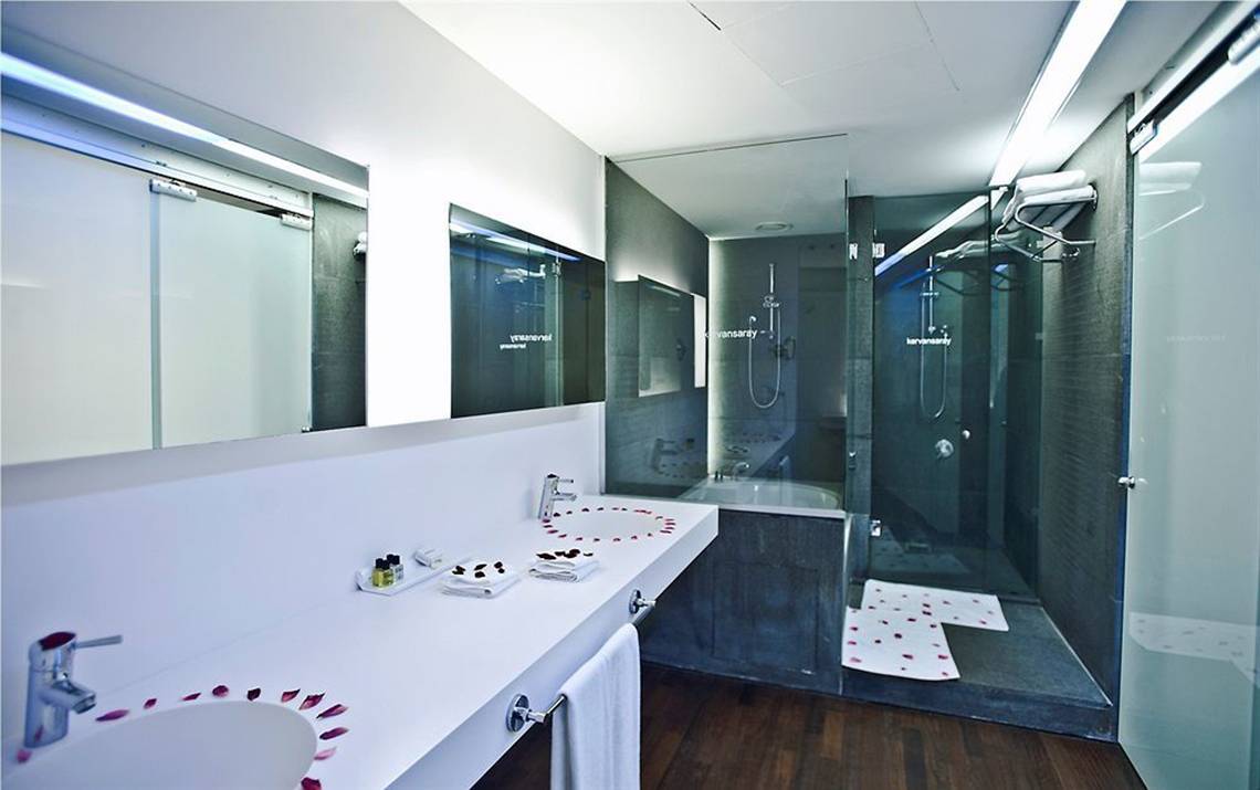 Badezimmer im Nirvana Cosmopolitan Hotel mit zwei Waschbecken, Dusche und Badewanne.