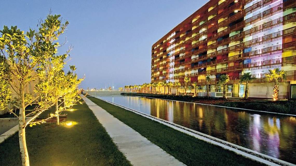 Außenansicht des Nirvana Cosmopolitan Hotels bei Nacht mit farbigen Lichtern und Wassergraben