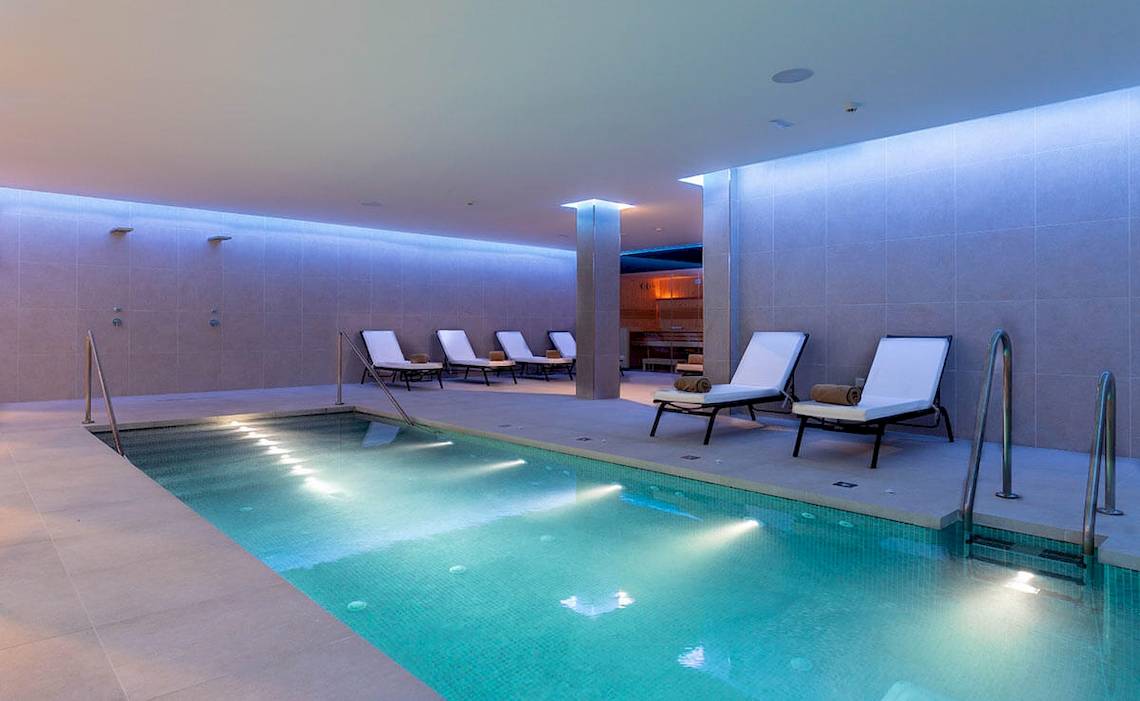 Innenpool im MAC Puerto Marina Hotel mit Lounge-Bereich und Wellnessbereich.