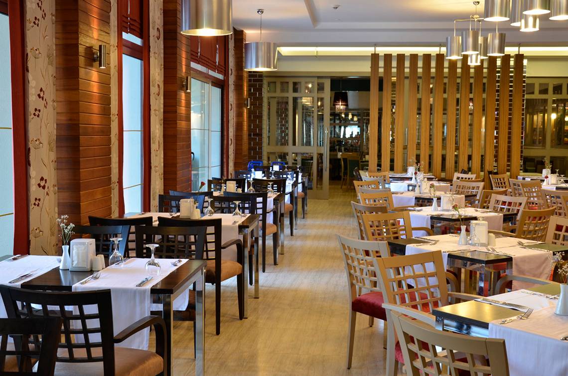 Innenansicht des Restaurants im Port Side Resort mit gedeckten Tischen und Stühlen.