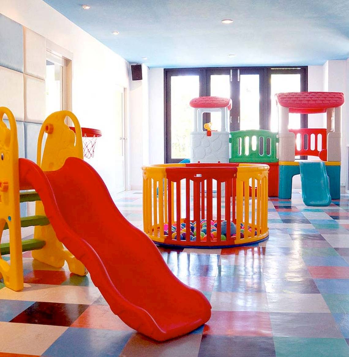 Kinderspielbereich im Apsara Beachfront Resort mit bunten Spielgeräten und einem großen roten Rutsch.