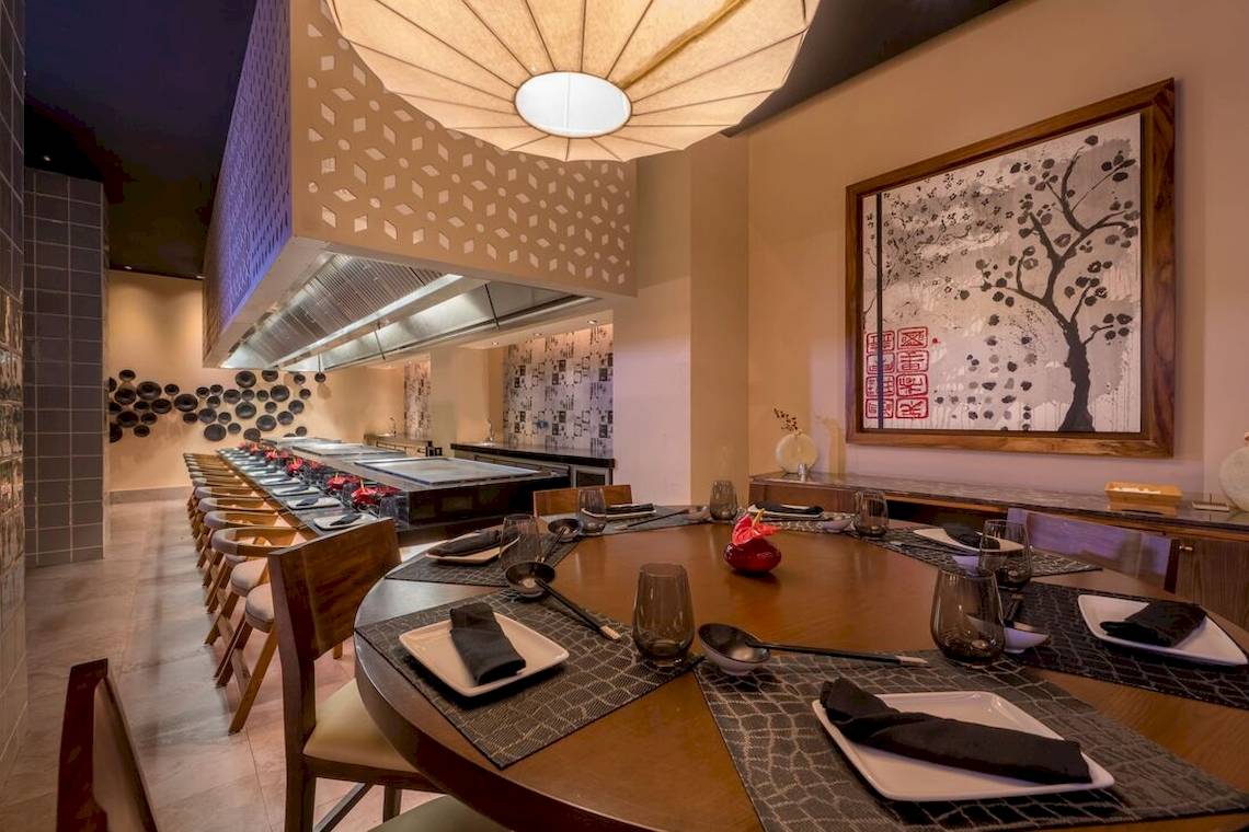 Innenraum des Haven Riviera Cancun Resort & Spa mit langer Esstisch und geometrischem Muster an der Decke.