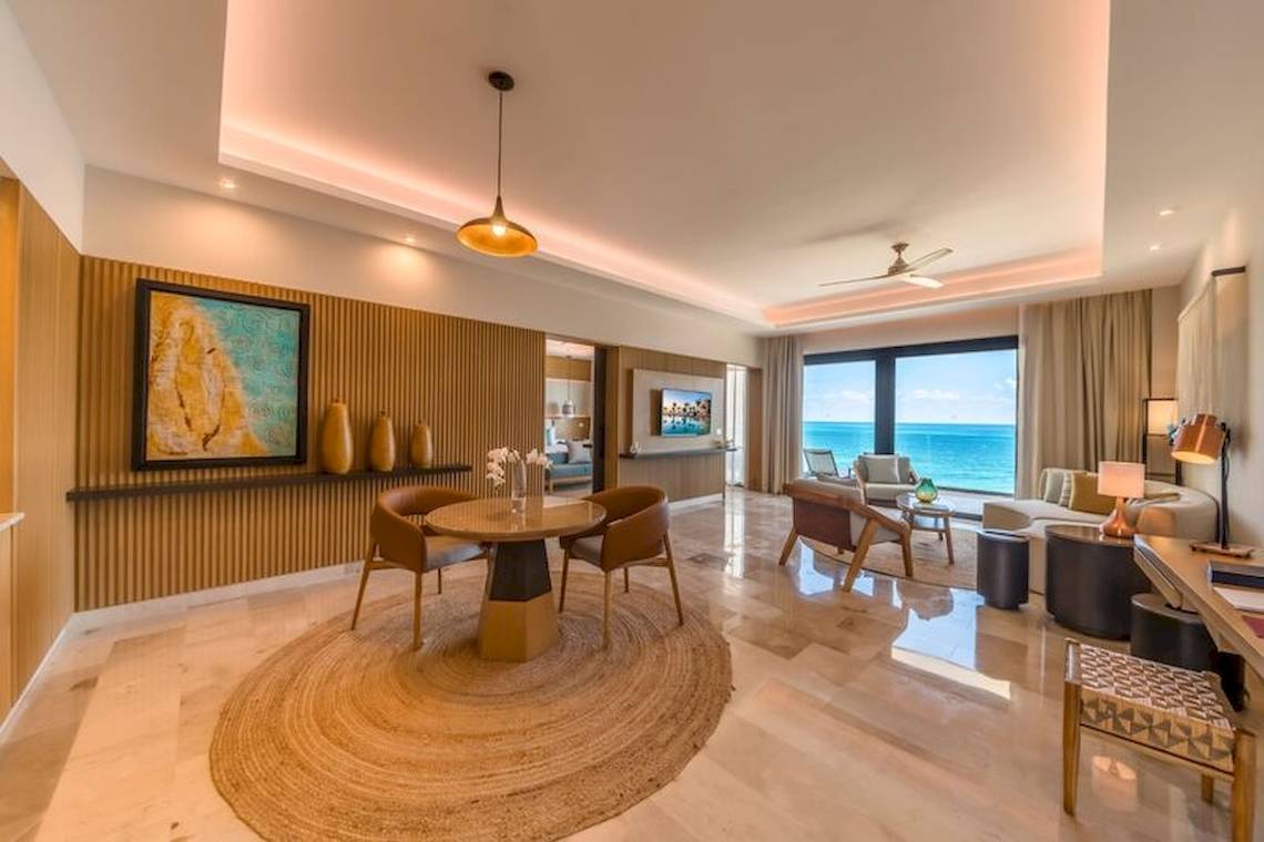 Innenraum des Haven Riviera Cancun Resort mit Esstisch, Sofa und Meerblick