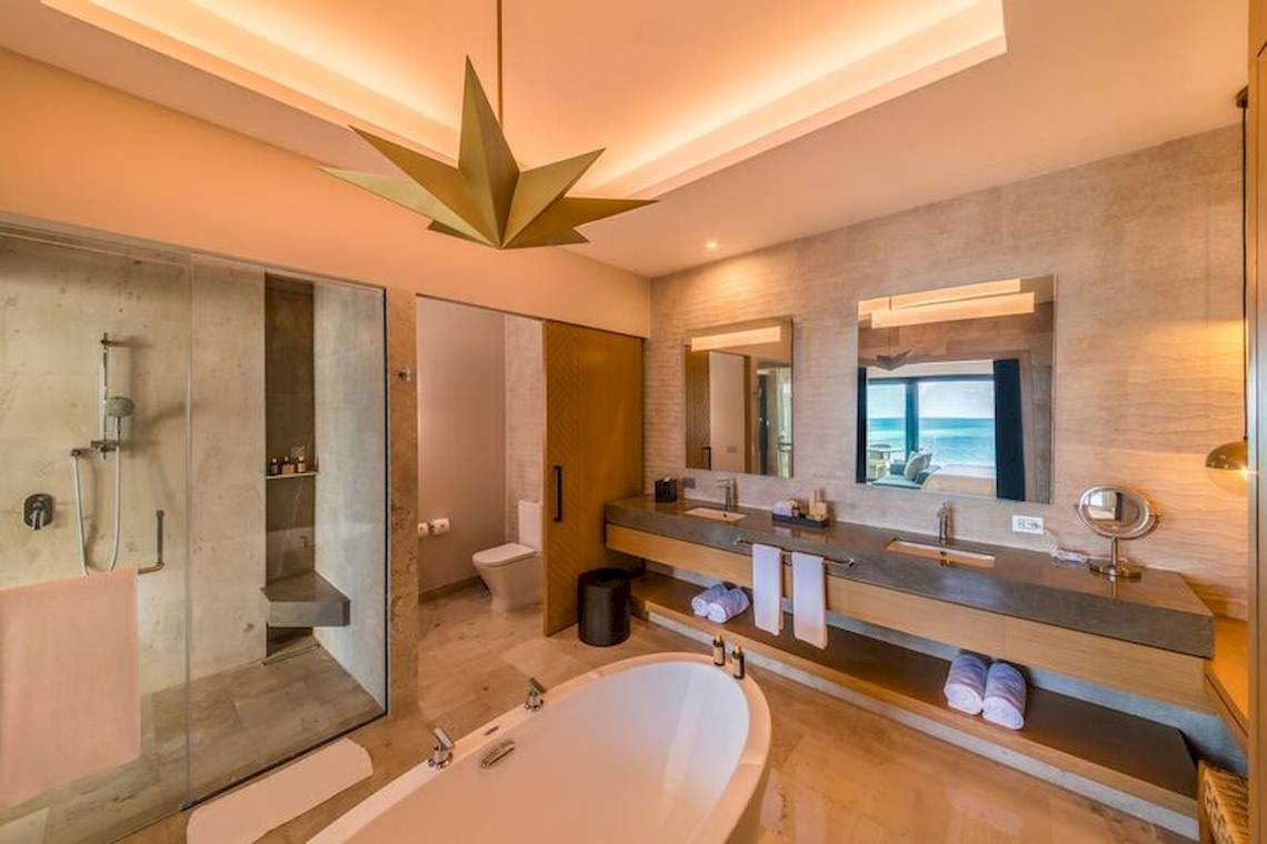 Luxuriöses Badezimmer im Haven Riviera Cancun Resort & Spa mit Badewanne, Dusche, Toilette und Doppelwaschbecken.