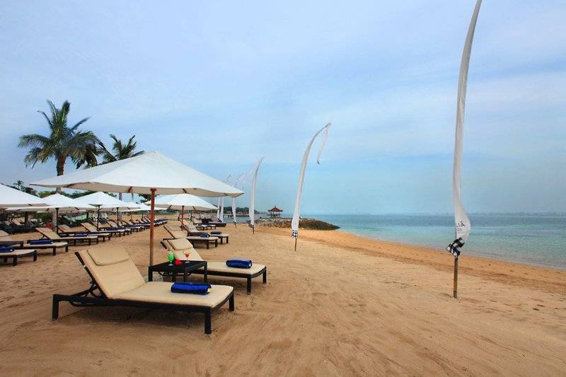 Strand des Sol Benoa Bali Hotels mit Liegen und Sonnenschirmen