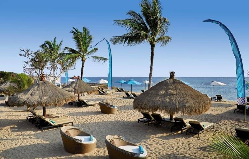 Strand mit Liegestühlen und Sonnenschirmen im Sol Benoa Bali Hotel