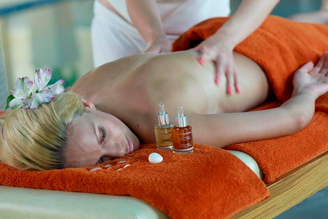Eine Frau erhält eine Rückenmassage im Spa des Royal Blue Resorts.
