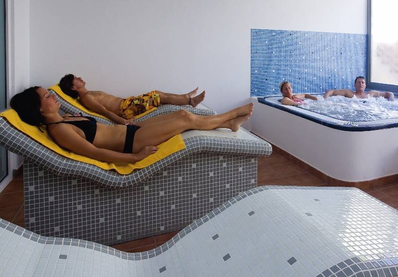 Spa-Bereich im SBH Royal Monica Hotel mit Liegen und Whirlpool.