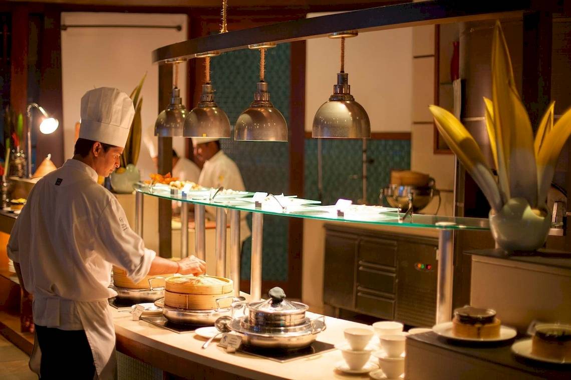 Koch im Restaurant des Constance Halaveli Maldives, der Gerichte zubereitet