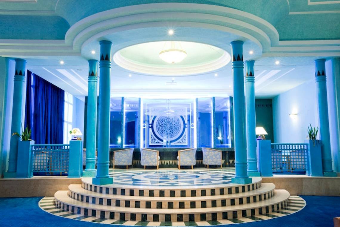 El Mouradi Mahdia Hotel Innenraum mit blauen Säulen und runden Sternenmuster.
