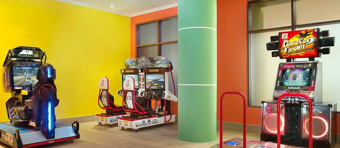 Spielraum im DoubleTree by Hilton Resort & Spa Marjan Island mit Arcade-Spielen und bunten Wänden