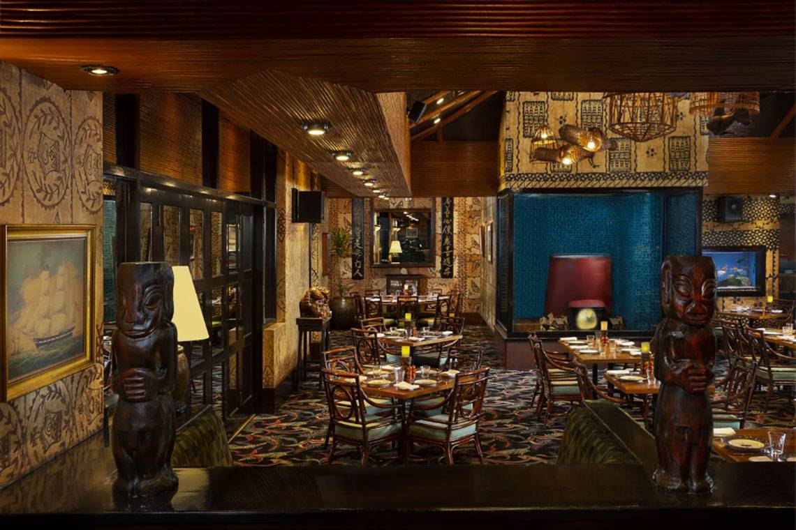 Innenansicht des Beach Rotana Restaurants mit Tisch, Stühlen und dekorativen Elementen.