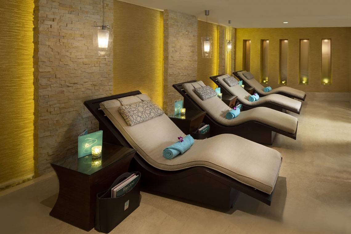 Spa-Lounge-Sessel im Beach Rotana Hotel, geordnet in einer Reihe mit Beistelltischen.