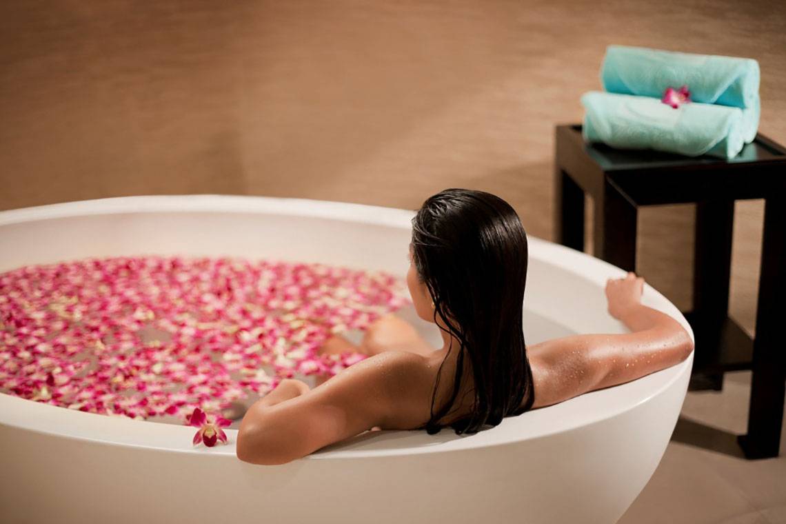 Frau im Badewann mit Blumen im Beach Rotana
