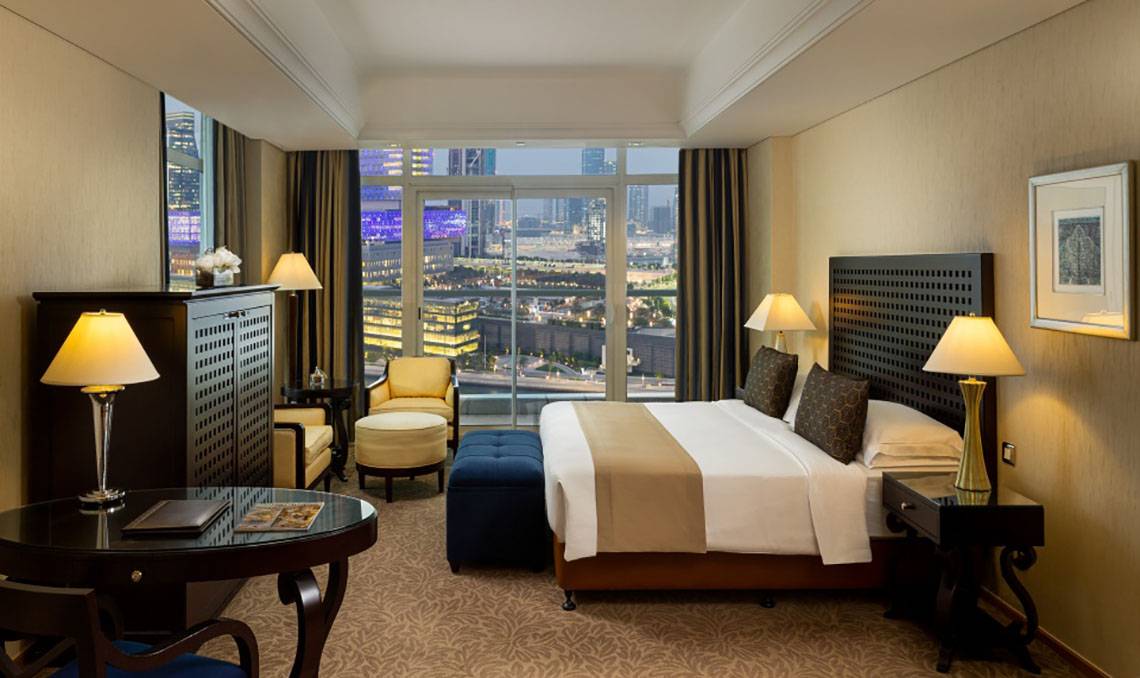 Innenansicht eines Schlafzimmers im Beach Rotana Hotel mit Blick auf die Stadt.