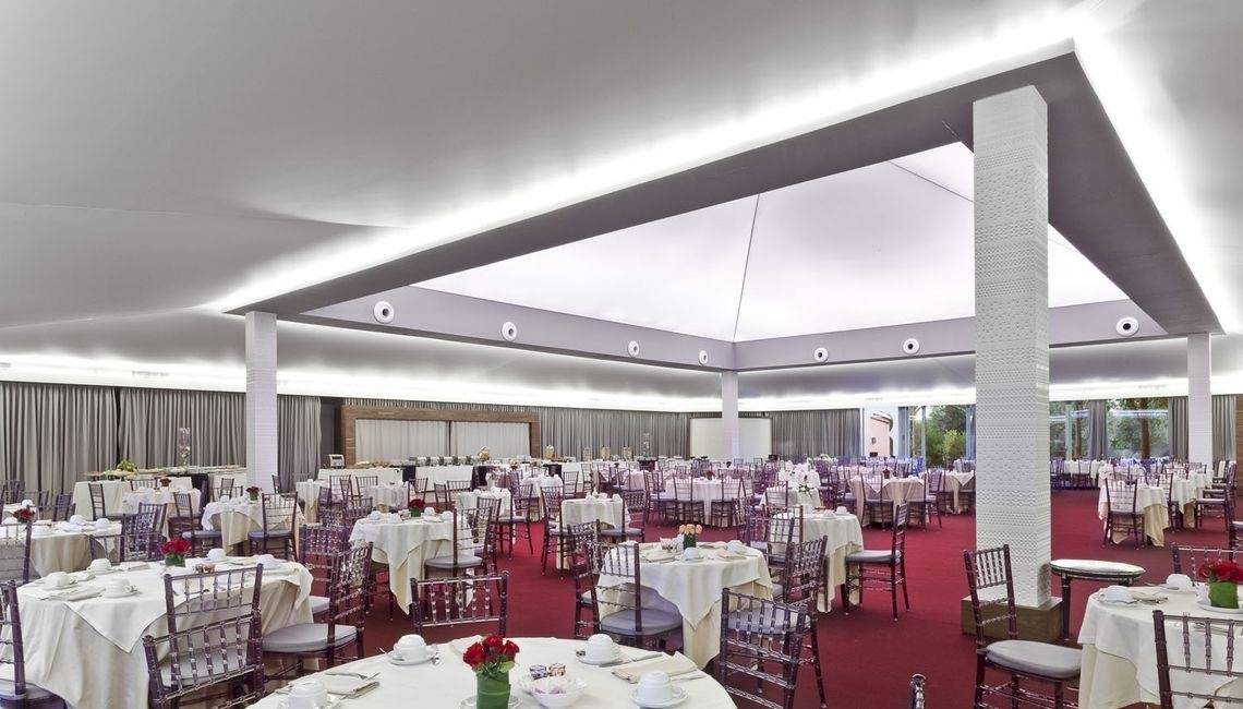 Bankettsaal im Palmeraie Palace Hotel mit vielen gedeckten Tischen und roten Teppich.