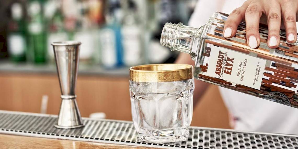 Ein Barkeeper im Myconian Korali Hotel gießt einen Cocktail in ein Glas.