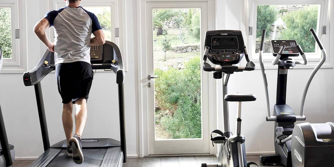 Mann läuft auf einem Laufband im Fitnessraum des Hotels Myconian Korali Relais & Chateaux.