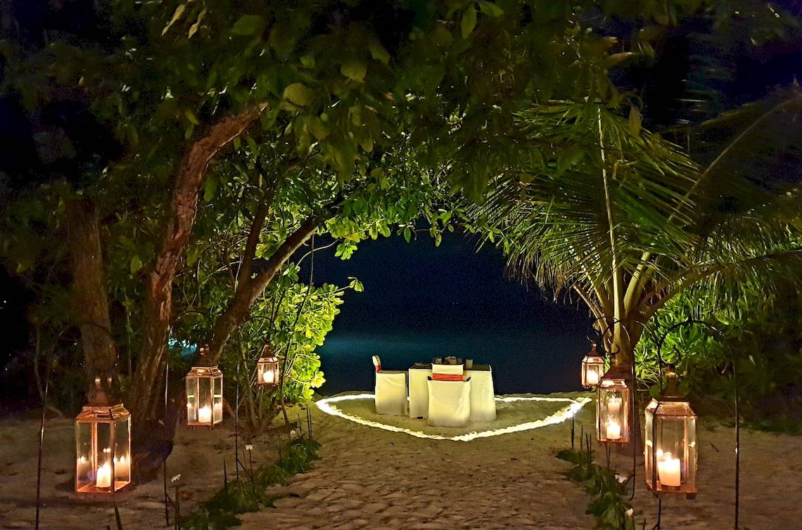 Romantisches Essen am Strand im Barefoot Eco Hotel mit brennenden Laternen.